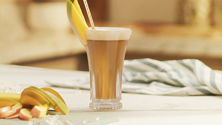 бокал с NESCAFÉ Фраппе Манго на столе бокал с NESCAFÉ Фраппе Манго на столе