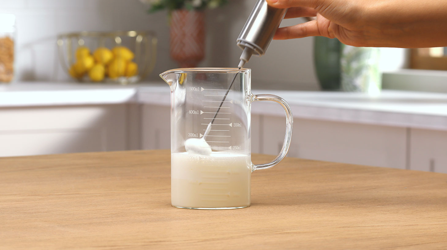 молоко взбивается беспроводным капучинатором в прозрачной емкости