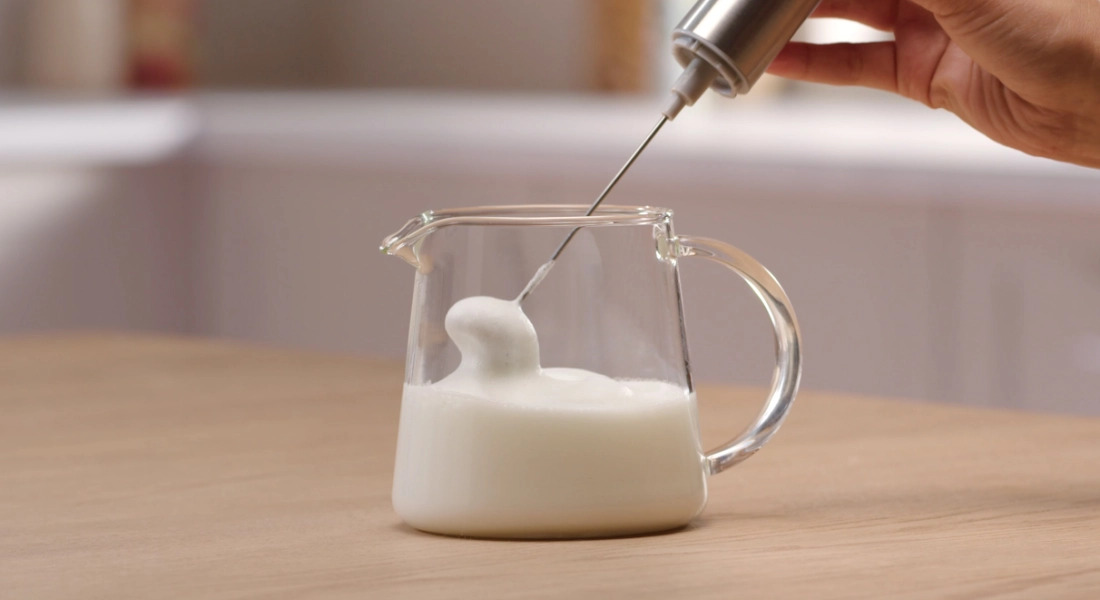 В отдельной емкости взбейте молоко до образования пенки