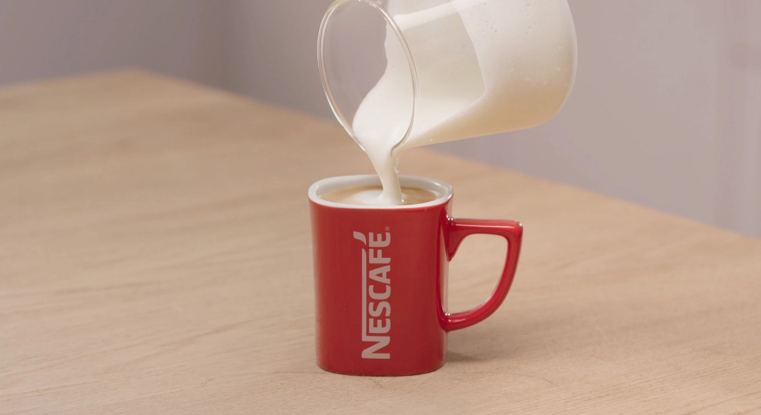 Добавьте взбитое молоко к кофе